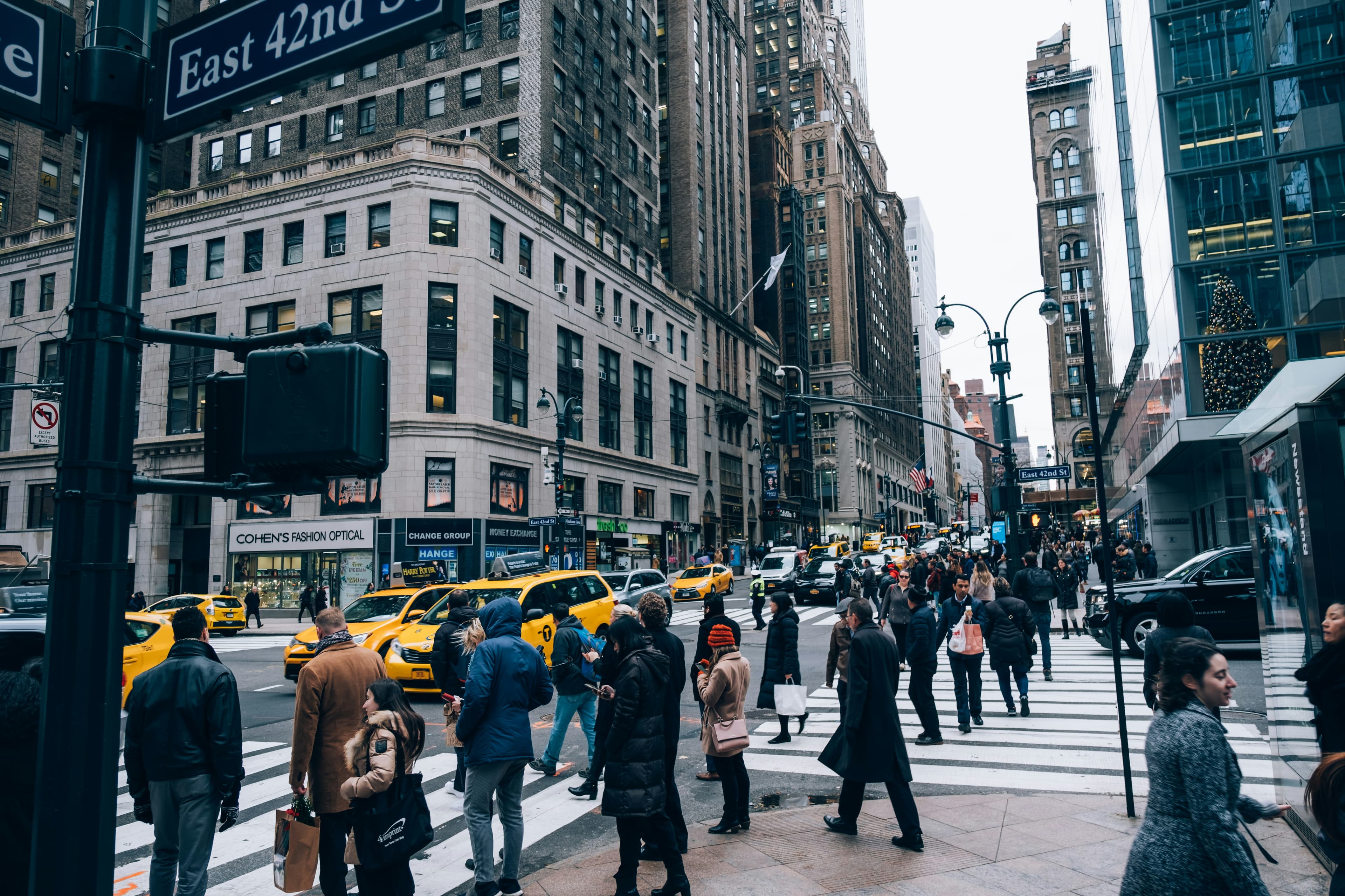 Pedestrians crossing a busy Midtown Manhattan intersection on East 42nd Street